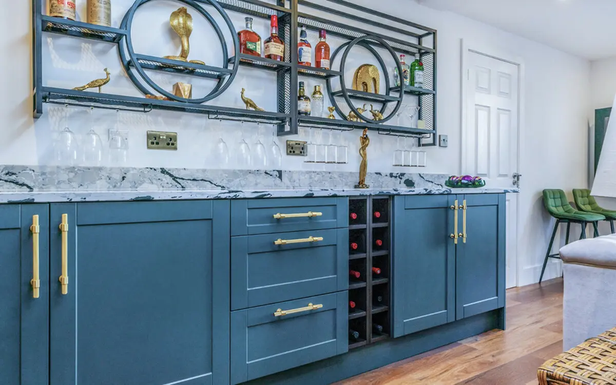 Fitted bar with navy cabinetry and gold details inside the completed garden building