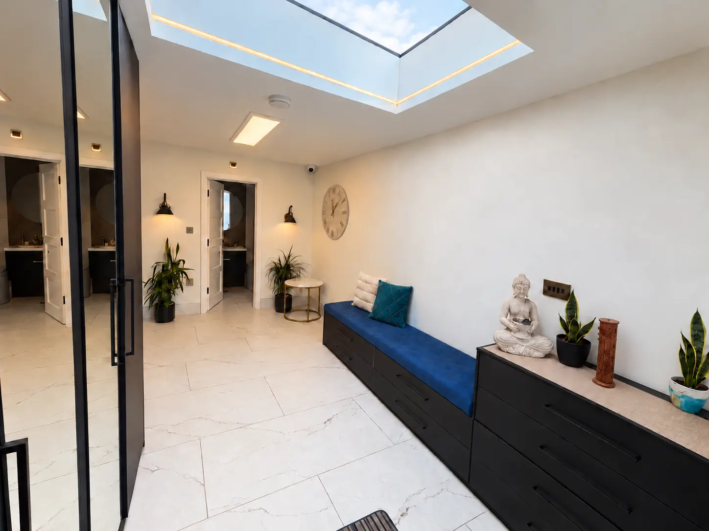 Bright entrance hall with rooflight and built-in bench at Farnham Royal