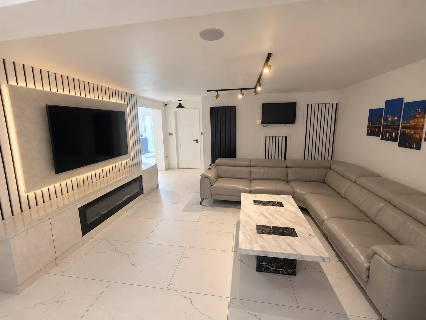 Finished living room with illuminated media wall at Farnham Royal